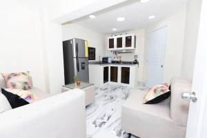 a white living room with a couch and a kitchen at Hermoso apartamento con Jacuzzi. in Santo Domingo