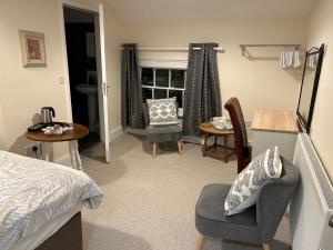 a bedroom with a bed and a chair and a table at The Unicorn Hotel in Caersws