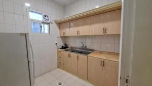 a kitchen with wooden cabinets and a sink at جولدن العرين Golden Al3areen abha hotel in Abha