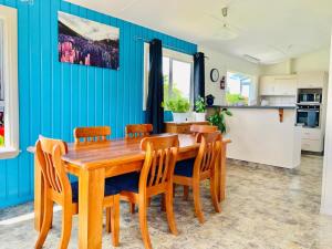 uma cozinha e sala de jantar com uma mesa de madeira e cadeiras em Central Garden Guest House em Motueka