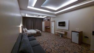a hotel room with a couch and a bed at جولدن العرين Golden Al3areen abha hotel in Abha