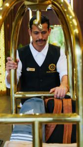 a man in uniform sitting on a gold chair at جولدن العرين Golden Al3areen abha hotel in Abha