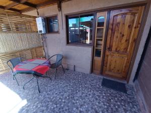 un tavolo e due sedie davanti ad una porta di Hostal Yurak a San Pedro de Atacama