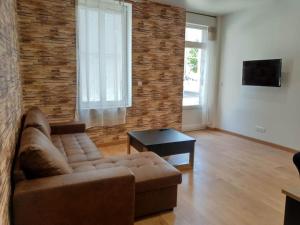 a living room with a couch and a brick wall at Gonnelles Appartement T3 Centre Ville RDC D in Agen