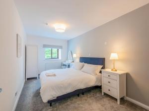 a bedroom with a bed with a nightstand and a lamp at The Barn House in Hawes