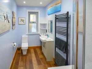 a bathroom with a white toilet and a sink at Uplands in Dalbeattie