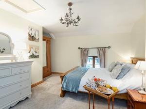 a bedroom with a bed with a table and a dresser at Horseshoe House - Ukc2743 in Watton