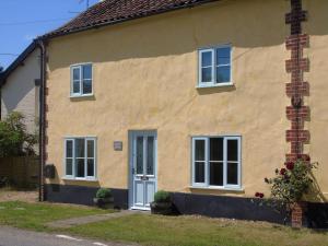 una casa gialla con porta blu e finestre di Horseshoe House - Ukc2743 a Watton