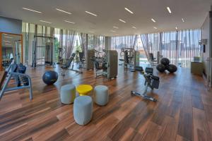 a gym with exercise equipment in a large room with wood floors at Park Life Guadalajara in Guadalajara