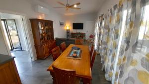 uma sala de estar com uma mesa de madeira e cadeiras em Cherry Mango Guesthouse em Apple Tree Creek