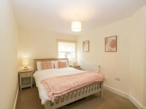 una camera con un letto e una coperta rosa di 9 Malthouse Court a Watchet