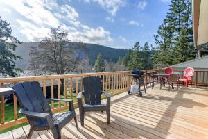 a deck with chairs and tables and a grill on it at Green Acres Lakeside Resort Salt Spring Island in Ganges