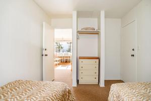 1 dormitorio con 2 camas, vestidor y ventana en Green Acres Lakeside Resort Salt Spring Island, en Ganges