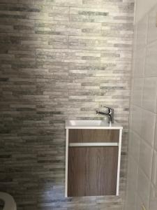 a bathroom with a sink and a brick wall at VC Alojamentos in Seia