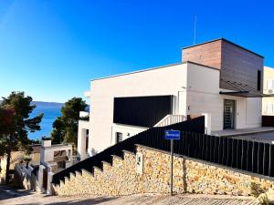 Ein weißes Gebäude mit einem Zaun davor. in der Unterkunft Luxury Beachfront Villa Carlisa in Ciovo