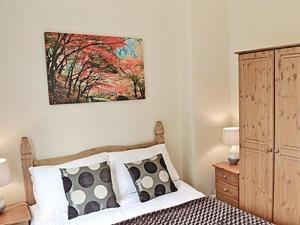 ein Schlafzimmer mit einem Bett und einem Wandgemälde in der Unterkunft Cartmel Cottage in Lindale