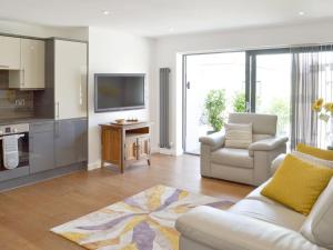 a living room with a white couch and a kitchen at Deepwater Point Apartment in Torquay