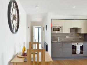 a kitchen with a table and a clock on the wall at Deepwater Point Apartment in Torquay