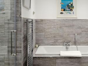 a bathroom with a bath tub and a sink at Deepwater Point Apartment in Torquay