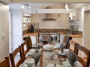 a dining room with a table and chairs and a kitchen at The Dun Cow in Bishop Middleham
