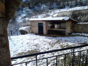un petit bâtiment avec de la neige au sol dans l'établissement Stone Mountainhouse near Kalavryta, North Peloponnese, Greece, 