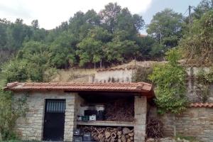 Cette petite maison en pierre est dotée d'une porte et d'un mur. dans l'établissement Stone Mountainhouse near Kalavryta, North Peloponnese, Greece, 