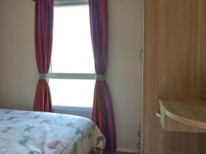 a bedroom with a window with red curtains at Stepen View in Chard