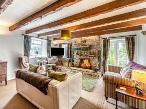 a living room with a couch and a fireplace at Cherry Tree Cottage in Burtree Ford