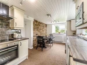 a kitchen and dining room with a table in it at Cherry Tree Cottage in Burtree Ford