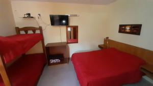a bedroom with two beds and a red couch at Apart Dany in Villa Los Molinos
