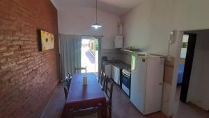 a small kitchen with a table and a refrigerator at Apart Dany in Villa Los Molinos