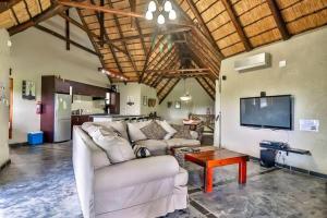 a living room with a couch and a tv and a table at Luxury Kruger Escape in Marloth Park