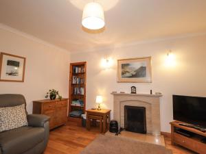 a living room with a couch and a fireplace at Craigard in Balmacara