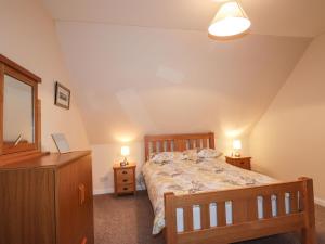a bedroom with a bed and a dresser with two lamps at Craigard in Balmacara
