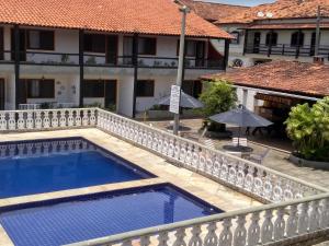 a swimming pool in front of a building at Refúgio Peró - Praia, piscina e churrasqueira in Cabo Frio