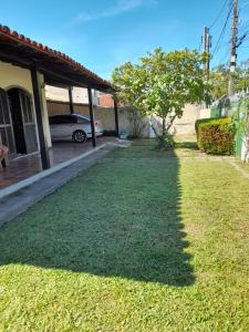 a yard of grass next to a house with a car at Cantinho da Lagoa in Araruama