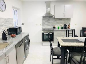 a kitchen with a table and a counter top at VC Alojamentos T2 in Seia