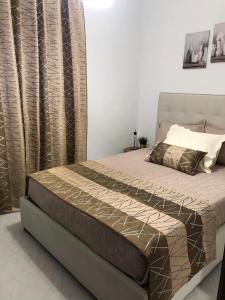 1 dormitorio con cama con colcha y cortinas marrones en VC Alojamentos T2, en Seia