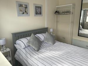 a bedroom with a bed with white sheets and pillows at Pebbles 144 South Shore 2 bed chalet 2 dog friendly, sleeps 4 in Bridlington
