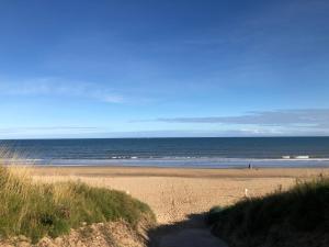 a sandy beach with the ocean in the background at Pebbles 144 South Shore 2 bed chalet 2 dog friendly, sleeps 4 in Bridlington