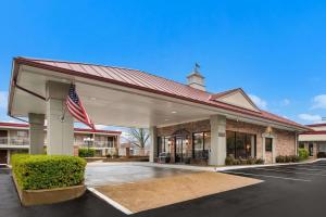 a building with an american flag in a parking lot at Best Western Winners Circle in Hot Springs