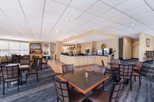 a dining room with tables and chairs and a kitchen at Best Western Winners Circle in Hot Springs