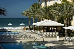 um resort com uma piscina e cadeiras e o oceano em Edgewater Beach Hotel em Naples