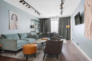 a living room with a couch and a table and chairs at Best Western Plus Grand Hotel Elektra in Ludvika