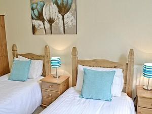 1 dormitorio con 2 camas y almohadas azules y blancas en Baycliff Apartment en Lindale