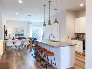 Una cocina con una gran isla con taburetes de bar. en BRAND NEW 3 bedroom near DISNEY / Wi-Fi / Parking, en Orlando