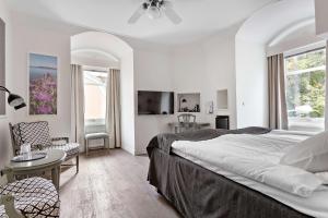 a white bedroom with a bed and a table and chairs at Sure Hotel by Best Western Centralhotellet in Västervik