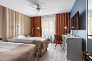 a hotel room with two beds and a desk at Sure Hotel by Best Western Centralhotellet in Västervik