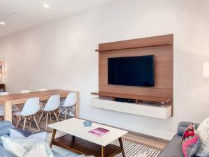 Una sala de estar con un televisor de pantalla plana en una pared. en BRAND NEW 3 bedroom near DISNEY / Wi-Fi / Parking, en Orlando