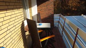 a table and chairs sitting on a balcony at Pension am Meer in Norddeich +19 photos